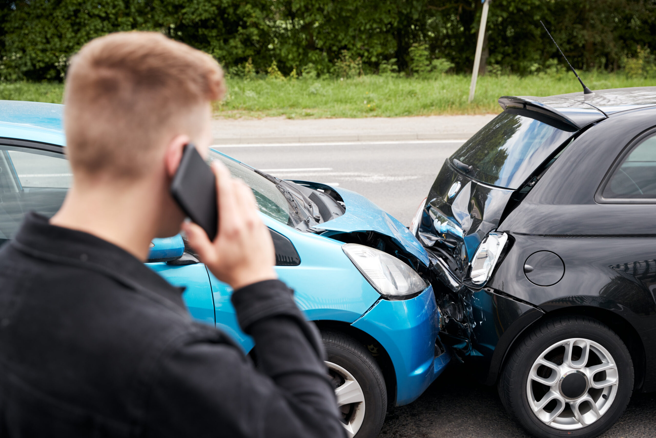Een bellende man tijdesn een verkeersongeval met letsel